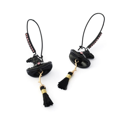 A pair of gothic-style black witch hat dangle earrings with gold-tone accents, small pink rhinestones, and black tassels, shown on a plain white background.