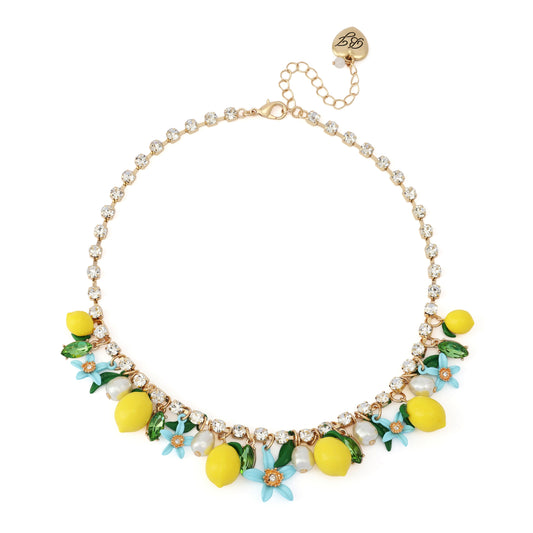 Necklace with yellow lemon and flower charms on a white background