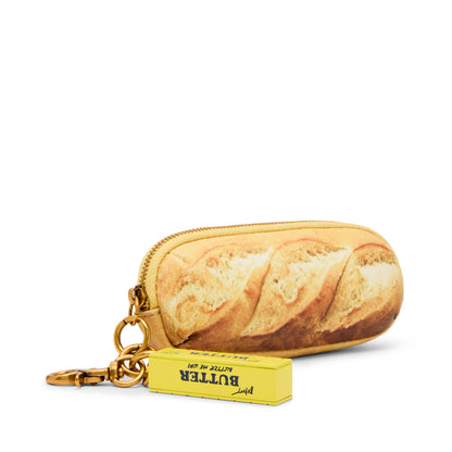 Keychain shaped like a loaf of bread with a butter container attached on a white background