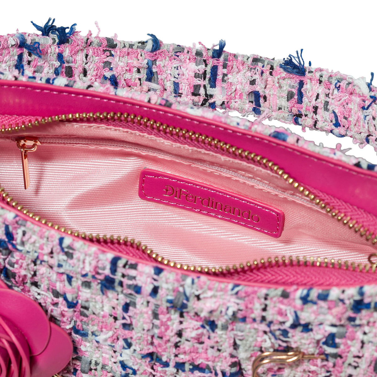 Close-up of a pink handbag with a tweed pattern and gold zipper, featuring the brand 'Ferdinand'.