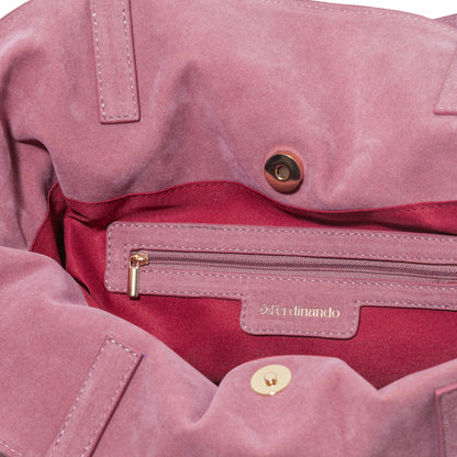 Close-up of a pink bag with gold zipper and button details, featuring the brand 'Ferdinando'.