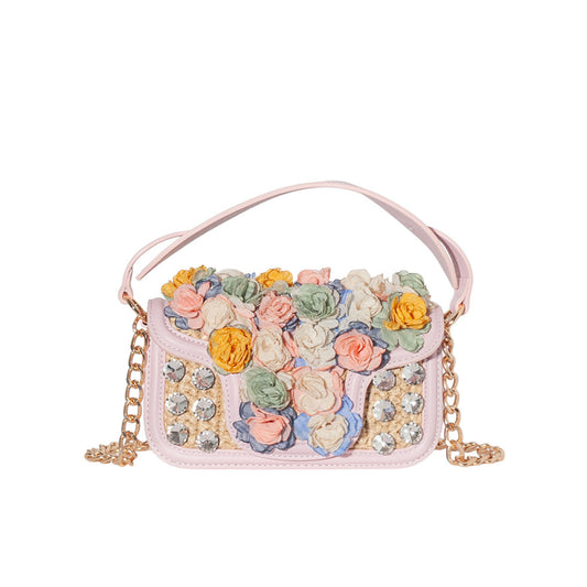 Pink handbag with floral embellishments and a chain strap on a white background
