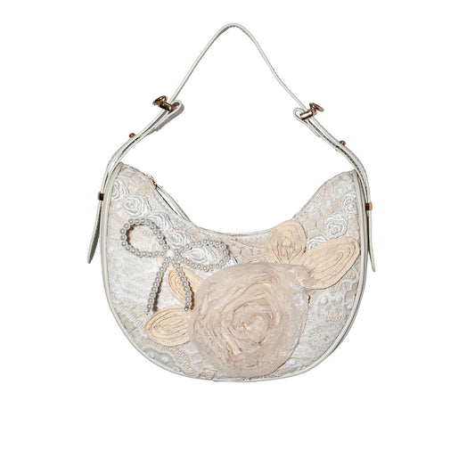 Handbag with floral design and lace details on a white background