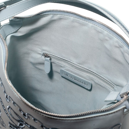 Close-up of a light blue handbag with a visible brand label on a white background